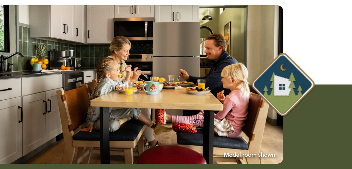 A family enjoys breakfast at the table inside a newly updated cabin.